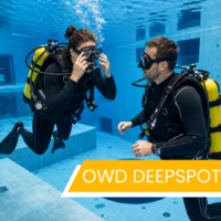 Kurs Open Water Diver SSI w Deepspot, kursantka ćwiczy zalewanie maski z instruktorem pod wodą